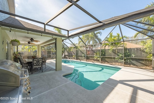 view of swimming pool featuring a lanai, ceiling fan, a patio area, and grilling area