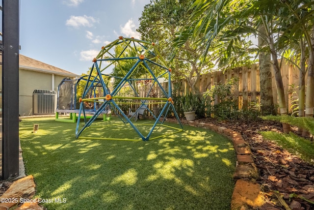 view of jungle gym featuring a yard, a trampoline, and cooling unit