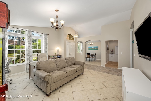 tiled living room featuring vaulted ceiling, an inviting chandelier, and a healthy amount of sunlight