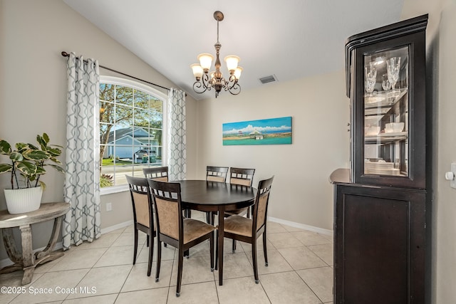 dining area featuring light tile patterned floors, lofted ceiling, and an inviting chandelier