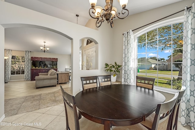 tiled dining area with a wealth of natural light and an inviting chandelier