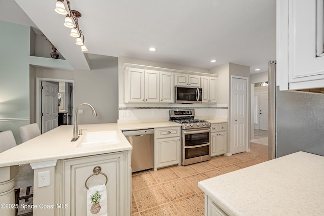 kitchen featuring sink, stainless steel appliances, decorative backsplash, a breakfast bar, and light tile patterned flooring