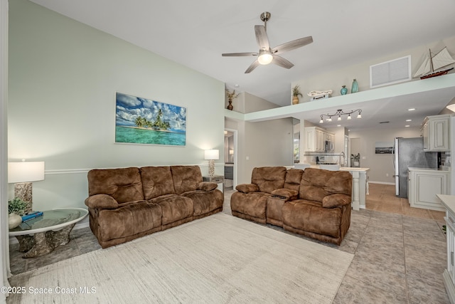 tiled living room featuring ceiling fan and sink