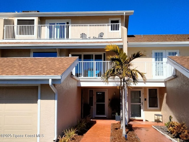 view of front of home featuring a garage and a balcony