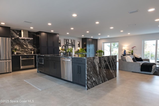 kitchen featuring appliances with stainless steel finishes, extractor fan, a kitchen island, and dark stone counters