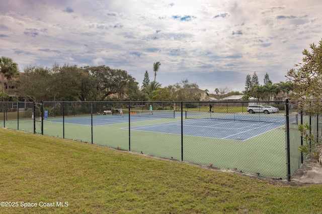 view of tennis court with a yard