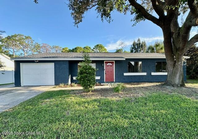 ranch-style home with a front lawn and a garage