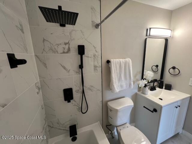 bathroom with toilet, vanity, and tiled shower