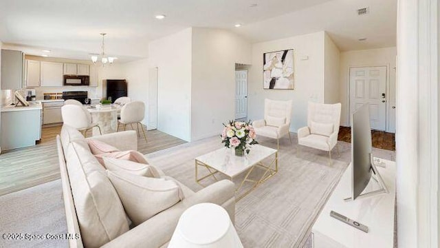 living room featuring a chandelier and light hardwood / wood-style floors