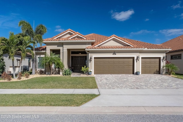 mediterranean / spanish house with a garage and a front lawn