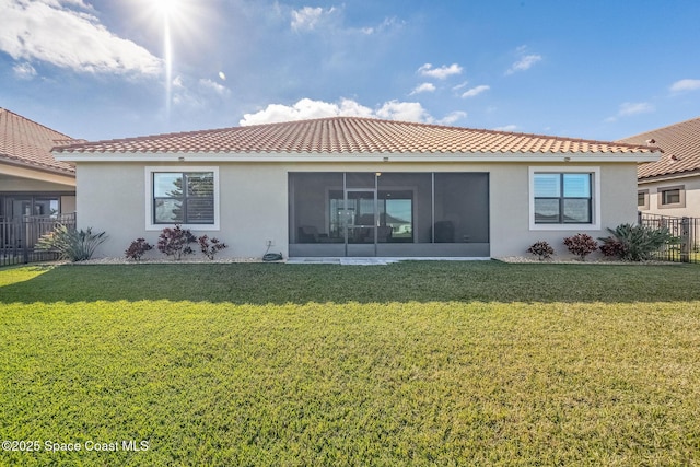 rear view of property featuring a sunroom and a lawn