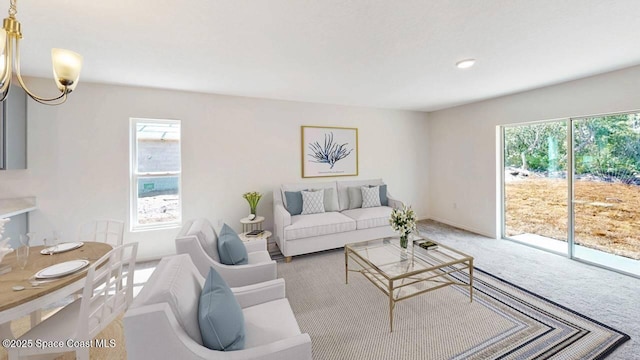 carpeted living room featuring a notable chandelier