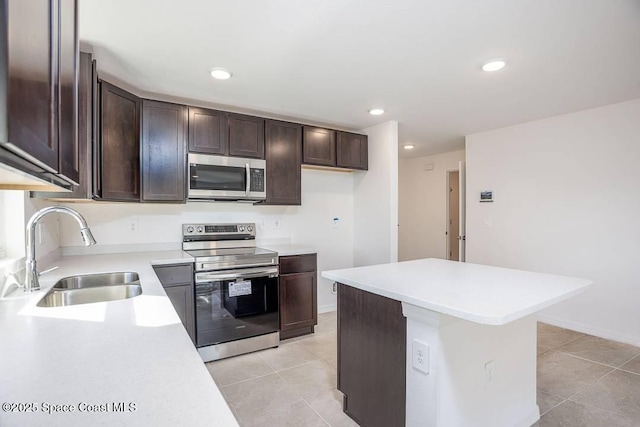 kitchen featuring light tile patterned floors, stainless steel appliances, dark brown cabinets, and sink