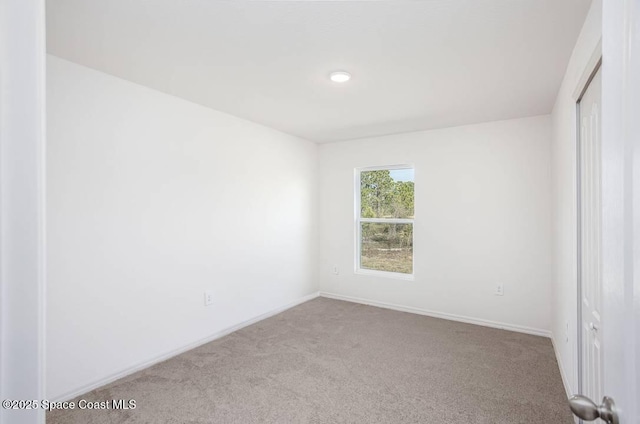 unfurnished room with light colored carpet