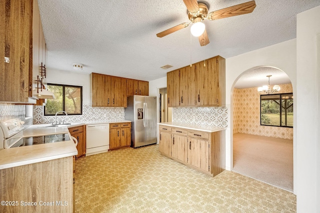 kitchen featuring range, a wealth of natural light, dishwasher, and stainless steel refrigerator with ice dispenser