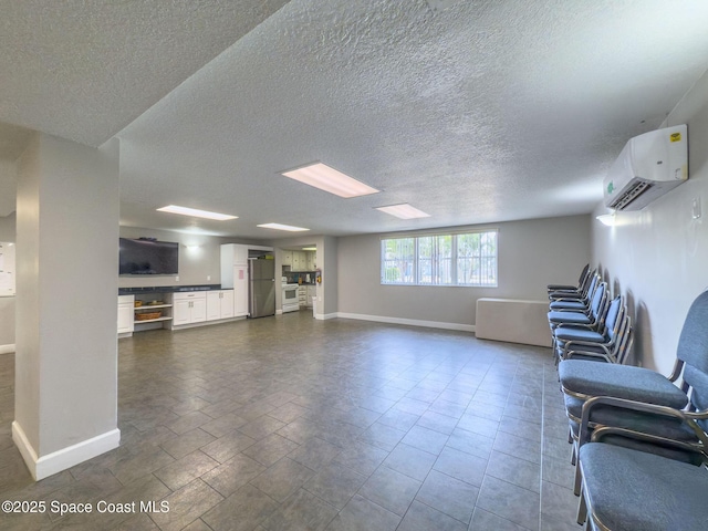 unfurnished living room with a textured ceiling and a wall unit AC