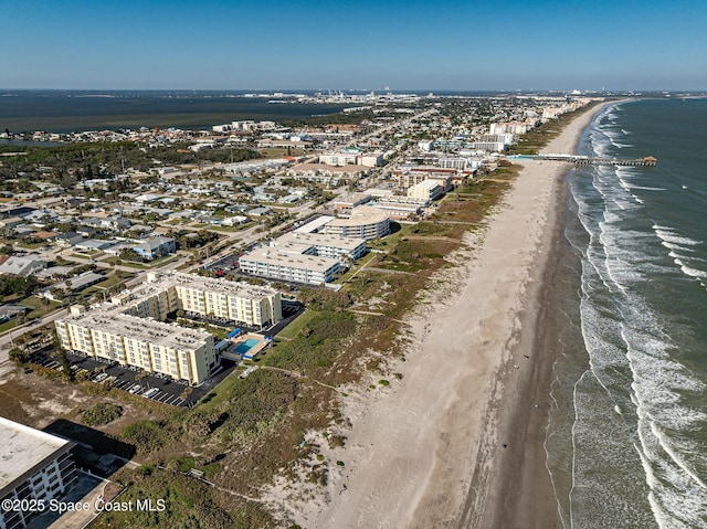 drone / aerial view featuring a water view and a beach view