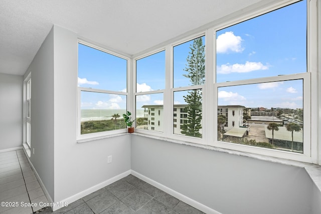 unfurnished sunroom featuring a water view