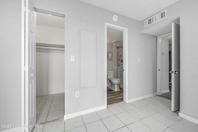 unfurnished bedroom with a closet, light tile patterned flooring, and a textured ceiling