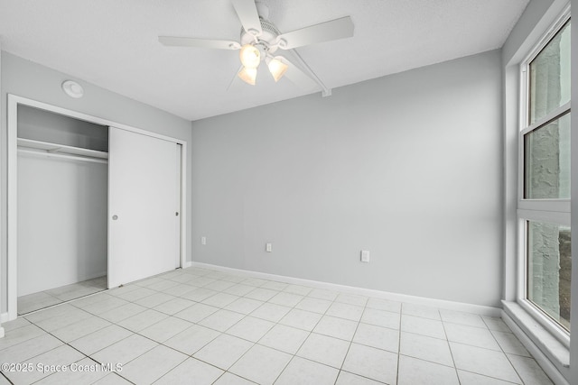 unfurnished bedroom with ceiling fan, a closet, and light tile patterned flooring