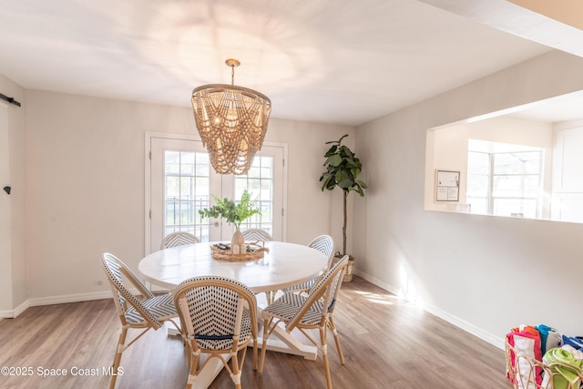 dining room featuring an inviting chandelier and light hardwood / wood-style flooring