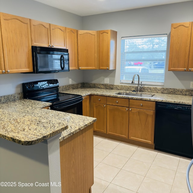 kitchen with light stone countertops, sink, light tile patterned floors, and black appliances