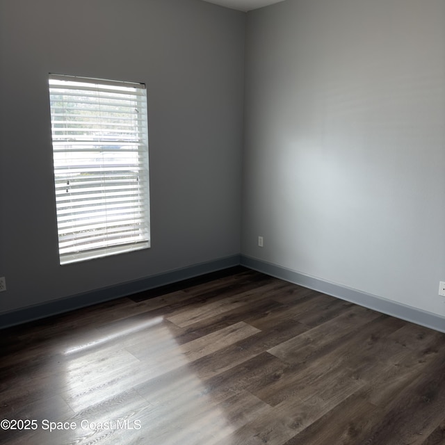 unfurnished room with dark hardwood / wood-style flooring