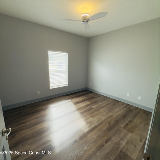 empty room with ceiling fan and dark wood-type flooring