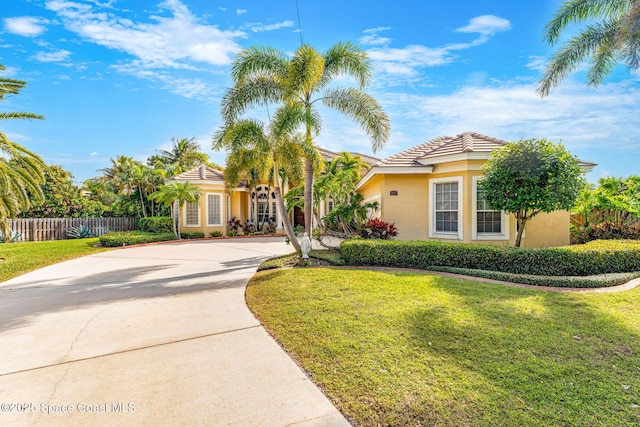 mediterranean / spanish home featuring a front lawn