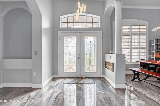 foyer entrance featuring hardwood / wood-style flooring, ornamental molding, and french doors