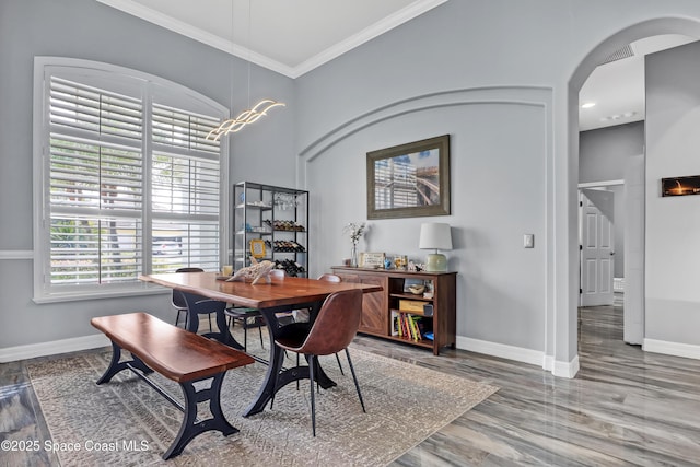 dining space with hardwood / wood-style floors and ornamental molding