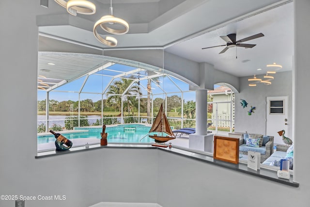 view of swimming pool featuring glass enclosure, ceiling fan, and a patio area