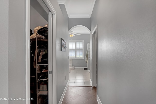 corridor featuring light tile patterned floors and ornamental molding