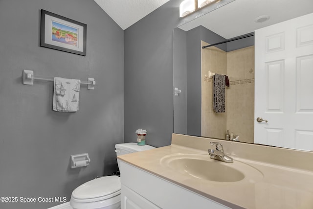 bathroom featuring vanity, vaulted ceiling, toilet, a textured ceiling, and a tile shower