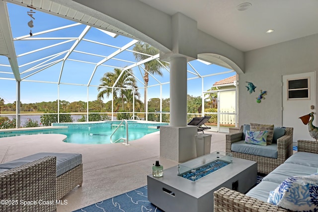 view of pool with a water view, glass enclosure, an outdoor living space with a fire pit, and a patio area