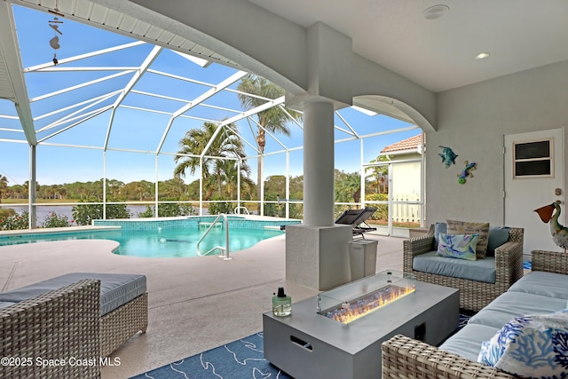 view of pool featuring an outdoor living space with a fire pit, a patio area, and glass enclosure