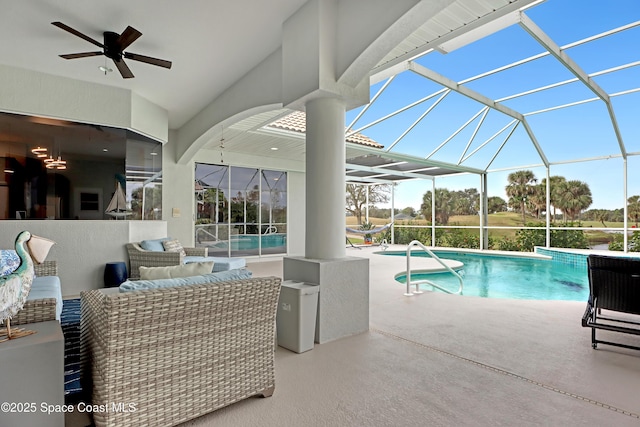 view of pool with glass enclosure, ceiling fan, a patio, and an outdoor hangout area