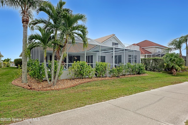 exterior space with a lanai and a front yard