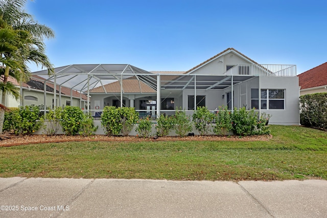 view of front of house with glass enclosure and a front lawn