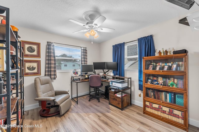 office featuring ceiling fan, light hardwood / wood-style floors, and a textured ceiling