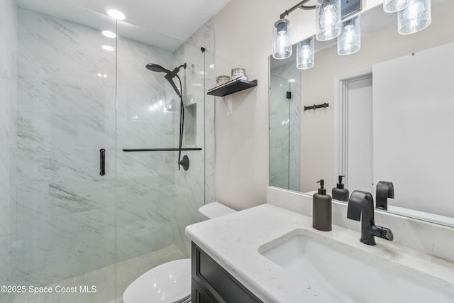 bathroom with vanity, a shower with shower door, and toilet