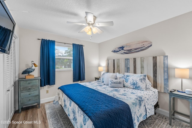 bedroom featuring hardwood / wood-style floors, a textured ceiling, and ceiling fan