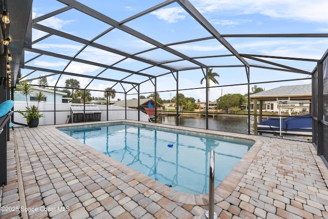 view of swimming pool featuring a water view, glass enclosure, and a patio area