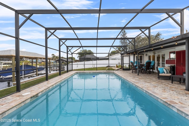 view of swimming pool featuring a lanai, a patio area, and ceiling fan