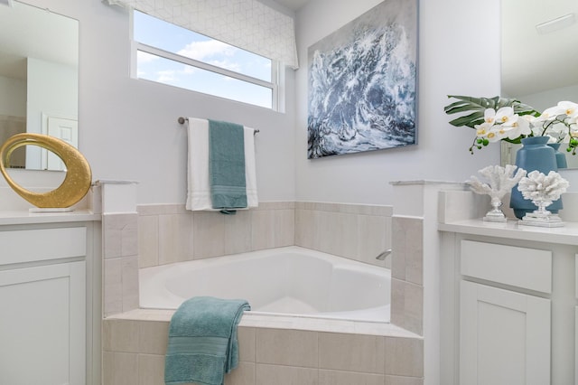 bathroom with vanity and tiled bath