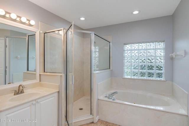 bathroom featuring vanity and independent shower and bath