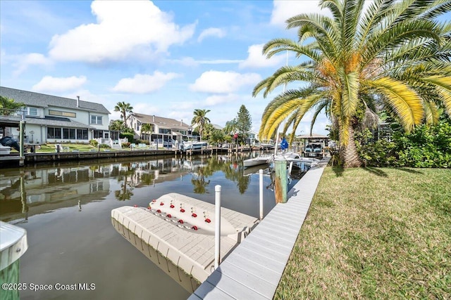 view of dock featuring a water view and a yard