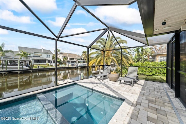 view of swimming pool featuring a patio, a water view, and a lanai