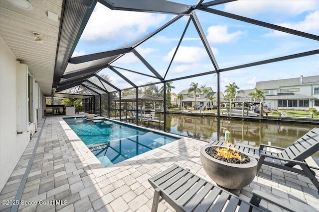 view of swimming pool featuring a fire pit, a patio area, a water view, and a lanai