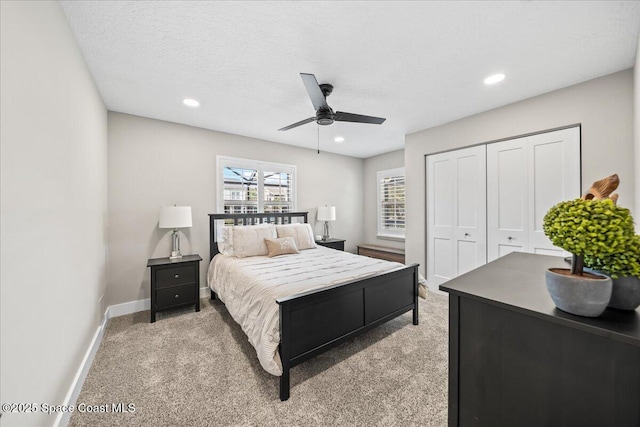 carpeted bedroom with ceiling fan, a textured ceiling, and a closet